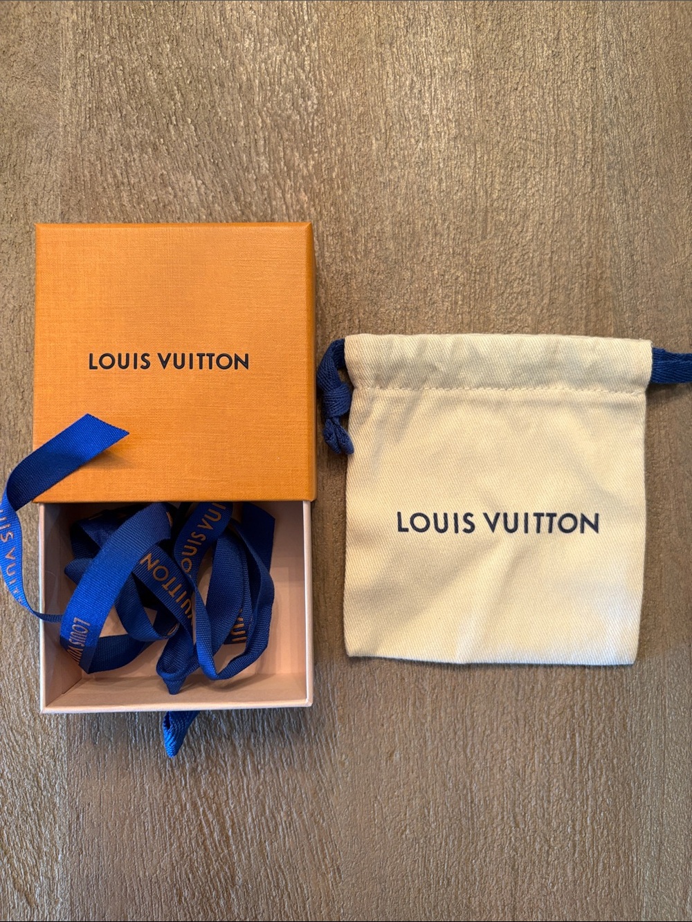 Louis Vuitton Orange Gift Box and Cream Drawstring Pouch with Blue Ribbon.